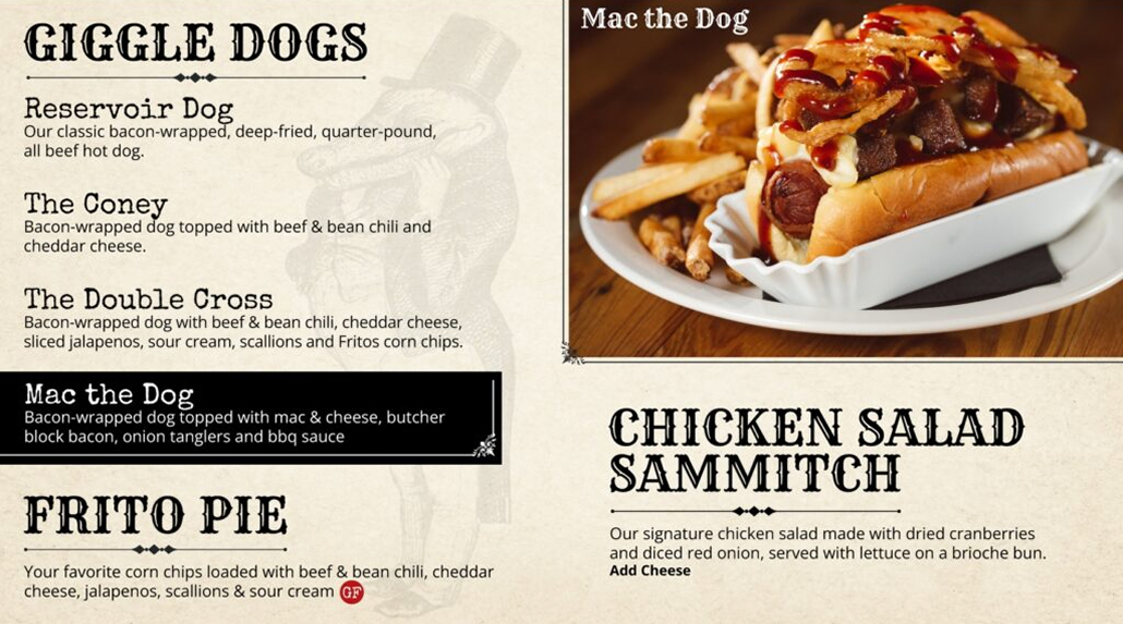 Giggle Dogs menu featuring specialty hot dogs and sides. Upper right shows 'Mac the Dog' - bacon-wrapped hot dog topped with mac and cheese, butcher block bacon, onion tanglers and BBQ sauce, served on a plate with fries. Menu lists Reservoir Dog (classic bacon-wrapped deep-fried quarter-pound hot dog), The Coney (topped with beef and bean chili and cheddar cheese), The Double Cross (with beef and bean chili, cheddar cheese, jalapenos, sour cream, scallions and Fritos), Mac the Dog, Frito Pie (corn chips loaded with beef and bean chili, cheddar cheese, jalapenos, scallions and sour cream), and Chicken Salad Sammitch (signature chicken salad with dried cranberries and diced red onion on brioche bun).